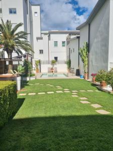 a backyard with a lawn and a courtyard with plants at Relaxing and Comforting in Olbia