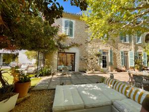 una casa in pietra con una panchina nel cortile di Maison Florence Ivakno a Coudoux