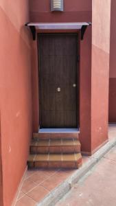 a door on the side of a building with stairs at Apartamento confortable en Mazagón in Mazagón