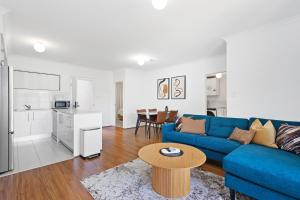a living room with a blue couch and a table at Comfort & Convenience - A Sepal Stay in Perth