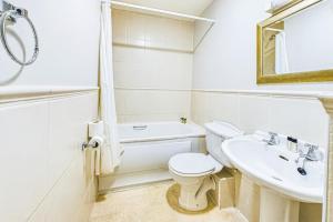 a white bathroom with a toilet and a sink at Faithlegg Mews, Faithlegg in Waterford +5 photos