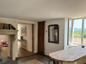 a living room with a table and a mirror at Maison Châteaux Lavandes in Grignan