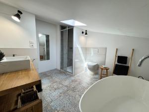 a bathroom with a tub and a toilet and a sink at Duplex de la Glacière Maison Châteaux & Lavandes in Grignan +15 photos
