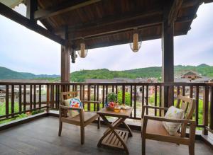 a porch with a table and chairs and a view at Zhangjiajie Countryard Hotel in Zhangjiajie