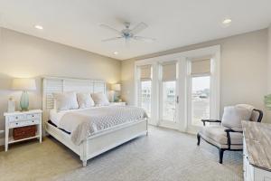 a bedroom with a white bed and a chair at No Time to Worry in Rockport +24 photos