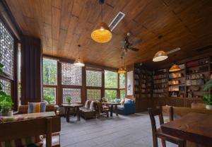 a large living room with wooden ceilings and windows at Zhangjiajie Countryard Hotel in Zhangjiajie