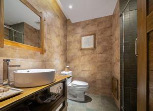 a bathroom with a sink and a toilet at Zhangjiajie Countryard Hotel in Zhangjiajie +63 photos