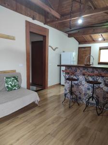 a room with a bed and a counter and a table at Refúgio do Sol in Lima Duarte
