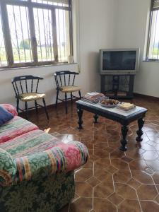 salon z kanapą, stołem i telewizorem w obiekcie Villa Rica House w mieście Negreira