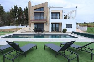 a house with a swimming pool and two lawn chairs at Villa Incognito With Pool - Perfect Hospitality in Thérmi