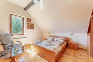 a small bedroom with a bed and a chair at Domek Marzeń Zatom in Zatom