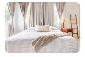 a bedroom with a white bed with a blanket at Casa Sofia in Guaynabo