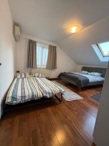 two beds in a room with wooden floors at Emun Grigo Lofthouse in Cluj-Napoca