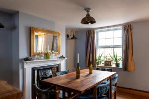comedor con mesa de madera y chimenea en Adorable quirky country cottage, en Heathfield
