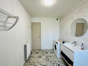 a bathroom with a sink and a washing machine at Studio Lumineux avec Balcon - Proche Gare & Centre in Montargis +14 photos