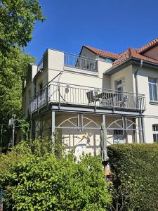 a building with a balcony on the side of it at NEU Nature Retreat - Traumhafte Wohnung mit privater Sauna - 100m vom Strand in Rerik