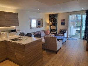 eine Küche und ein Wohnzimmer mit einer Couch und einem Tisch in der Unterkunft Top floor luxury riverfront apartment in Woolwich