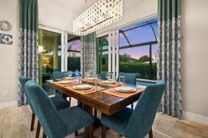 a dining room with a wooden table and blue chairs at Casa Palma - 5 Min to Beach, Heated Pool, Hot Tub, New Build in Marco Island