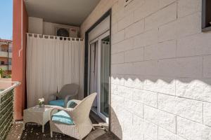 a patio with chairs and a table on a balcony at Appartamento Veronese in Olbia