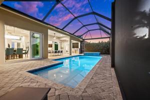 an indoor swimming pool in a house with a glass roof at Casa Palma - 5 Min to Beach, Heated Pool, Hot Tub, New Build in Marco Island +28 photos