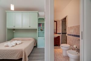 a bedroom with a bed and a toilet and a sink at Appartamento Veronese in Olbia +93 photos