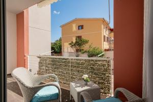 a balcony with chairs and a table and a building at Appartamento Veronese in Olbia