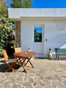 a wooden table and two chairs next to a house at Villa Joyosa Apartments in Ischia Town