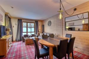 a living room with a wooden table and chairs at Appartement 60 m2 grand balcon plein sud ARC 1950, piscine, sauna, hammam in Arc 1950