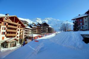 a snow covered street in a ski resort with buildings at Appartement 60 m2 grand balcon plein sud ARC 1950, piscine, sauna, hammam in Arc 1950