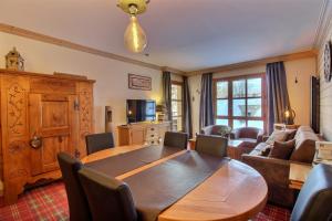 a living room with a wooden table and a couch at Appartement 60 m2 grand balcon plein sud ARC 1950, piscine, sauna, hammam in Arc 1950