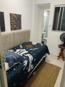 una camera da letto con un letto con un piumone blu sopra di Casa de praia a Salvador Altre 8 foto