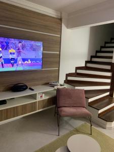 un soggiorno con scala e televisore di Casa de praia a Salvador