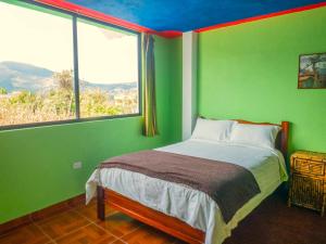 a bedroom with green walls and a bed with a window at Green House Araque Inn in Otavalo +195 photos