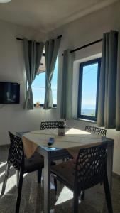 a dining room with a table and chairs and a window at Sa Mesaluna Naturhouse in Ilbono