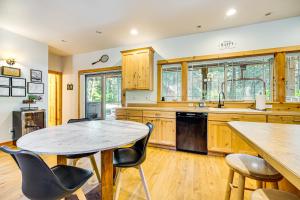 una cocina con armarios de madera, mesa y sillas en Cle Elum Lake Home with Hot Tub and Mountain Views, en Ronald