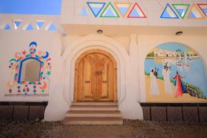 a building with a door and paintings on the walls at Kaya Nubian House in Aswan