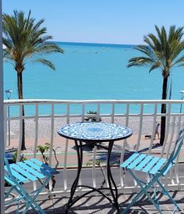 - Balcón con mesa y sillas y vistas a la playa en Appartements Au Cros De Cagnes, en Cros-de-Cagnes