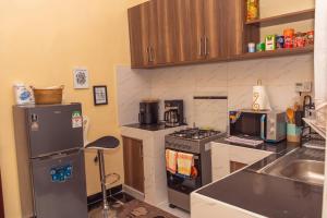 a small kitchen with a refrigerator and a stove at ivorymanorhost in Bungoma