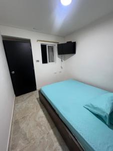 a small bedroom with a bed and a black door at Hostal Jireth in Floridablanca +10 photos