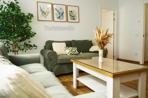 a living room with a couch and a table at Apartamento Corimar - Céntrico y accesible para personas con movilidad reducida in San Vicente de la Barquera +27 photos