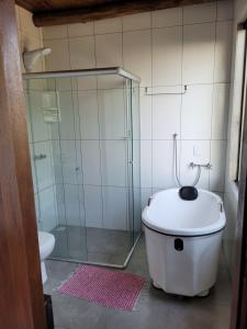 a bathroom with a tub and a glass shower at Rancho Smaniotto 1783 in Dois Irmãos