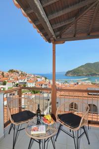 a balcony with a table and chairs and a view of the ocean at Home Sweet Home in Skopelos Town