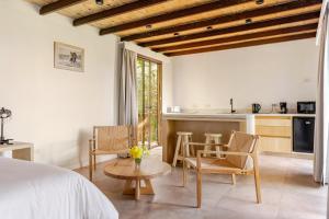 ein Schlafzimmer mit einem Bett, einem Tisch und Stühlen in der Unterkunft Las Nandinas - Olivo in Ciudad Lujan de Cuyo