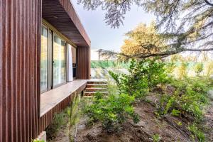 ein Haus auf einem Hügel mit einer Holzveranda in der Unterkunft Las Nandinas - Olivo in Ciudad Lujan de Cuyo
