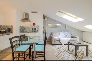 Una sala de estar con una mesa de cristal y sillas. en Appartements Au Cros De Cagnes, en Cros-de-Cagnes