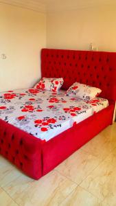 a red bed with a red headboard in a bedroom at Service Apartment in Kunkwaba
