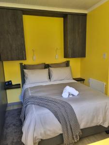 a bedroom with a large bed with a towel on it at Cosy Cottage in East London