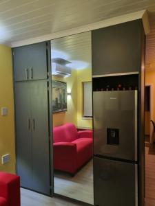 a living room with a red couch and a sliding glass door at Cosy Cottage in East London
