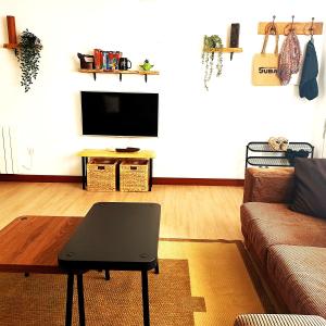 a living room with a couch and a tv at Casa frente al mar en Boiro in Magdalena