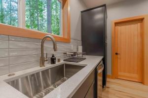 a kitchen with a stainless steel sink and a black refrigerator at 15GS - Hot Tub - WIFI- Pets Ok in Deming +22 photos